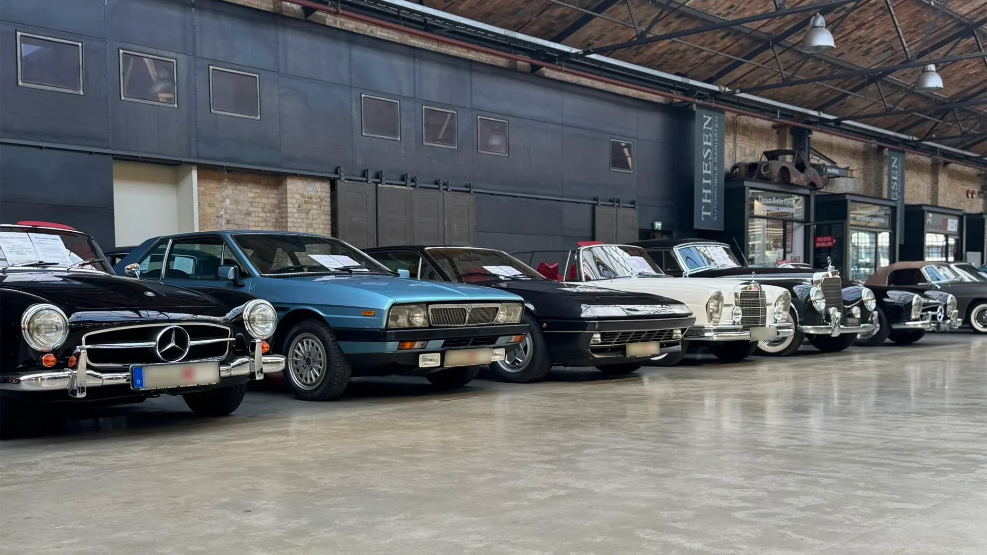 Klassische Fahrzeuge in der Halle der Classic Remise Berlin, vorn ein Mercedes 190 SL