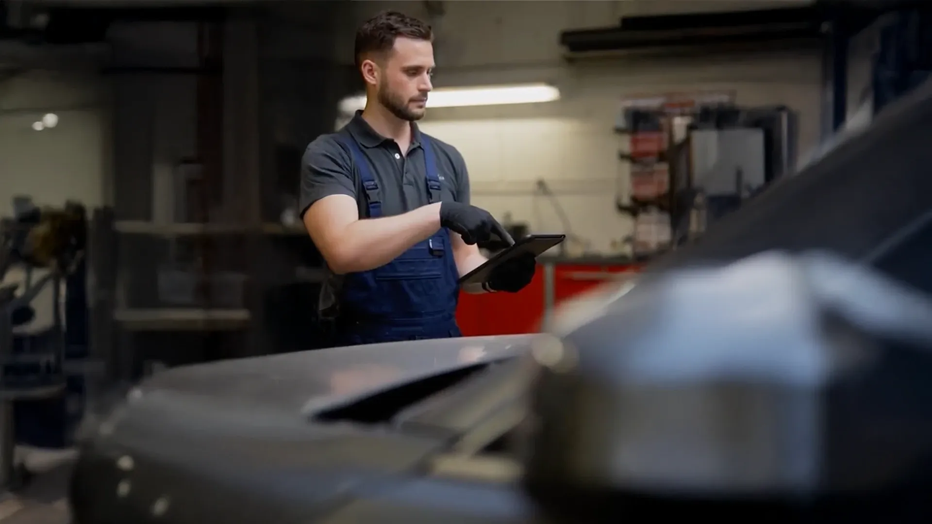 Kfz-Mechaniker mit Tablet bei der Arbeit in der Werkstatt
