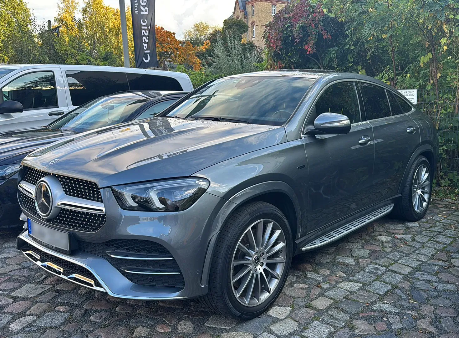 Graues Mercedes GLE Coupé vor der Werkstatt im Herbst