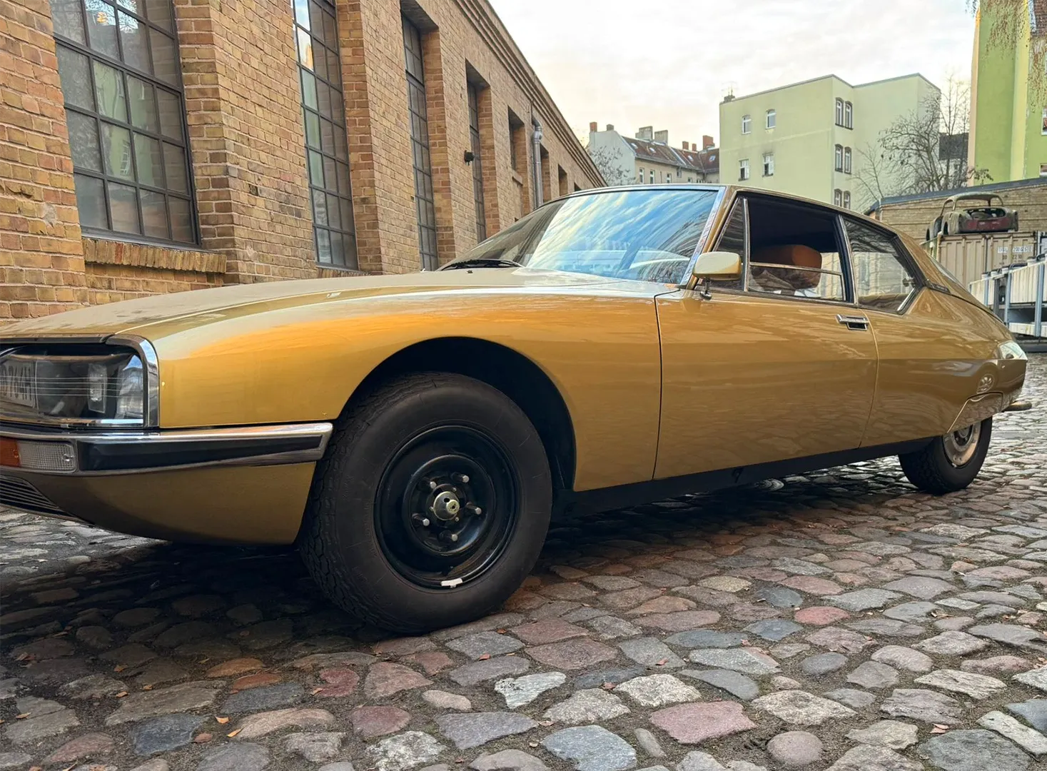 Goldfarbener Citroën SM in Seitenansicht auf Kopfsteinpflaster