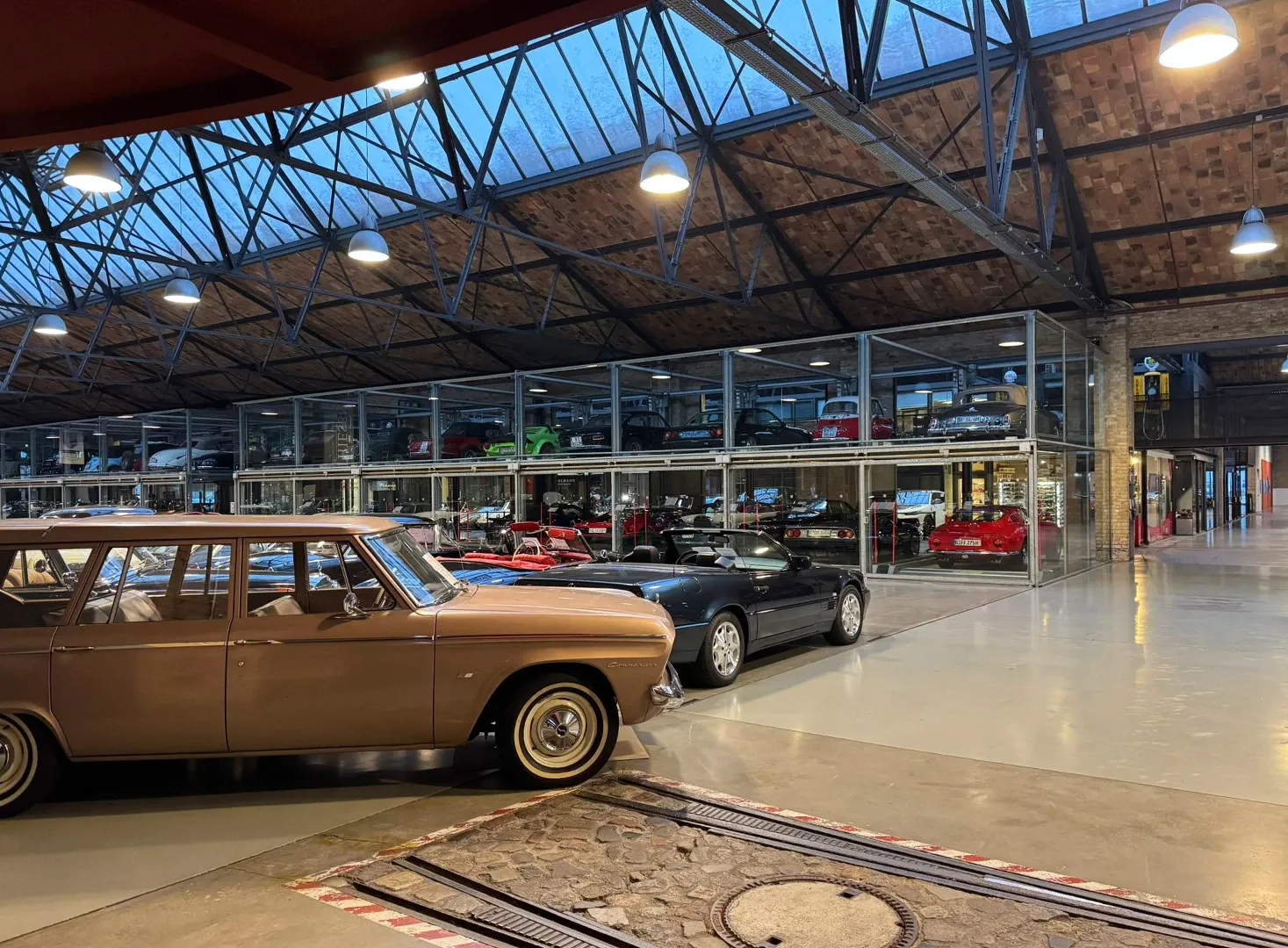 Halle der Classic Remise Berlin mit Oldtimern, vorn ein beiger Mercedes Coupé