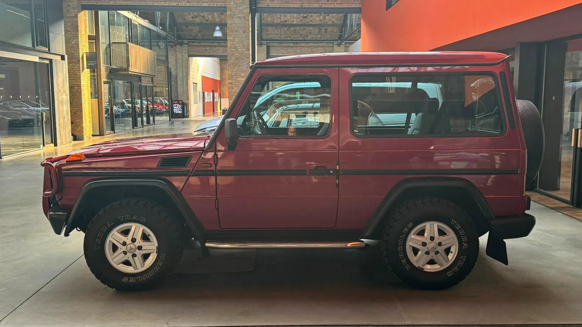 Dunkelrote Mercedes G-Klasse im Showroom der Classic Remise