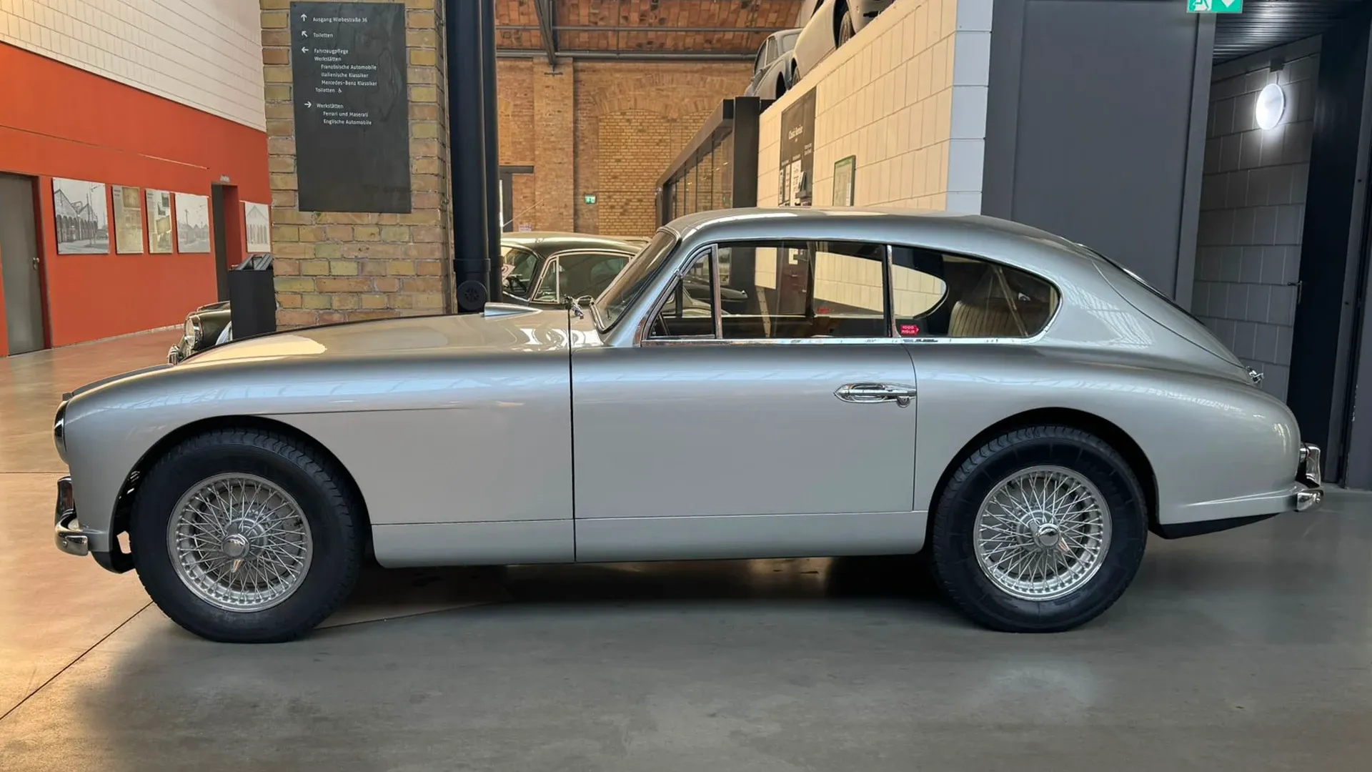 Silbernes klassisches Coupé vor dem Showroom der Classic Remise